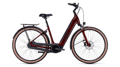 On voit un vélo électrique Cube Supreme Hybrid Pro rouge foncé, avec un cadre bas.
