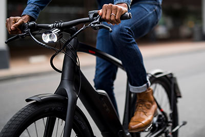 On voit un gros plan d'un cycliste sur un vélo de Trek noir.