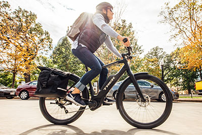 Un homme roule à vélo noir, de marque Trek, dans une rue.