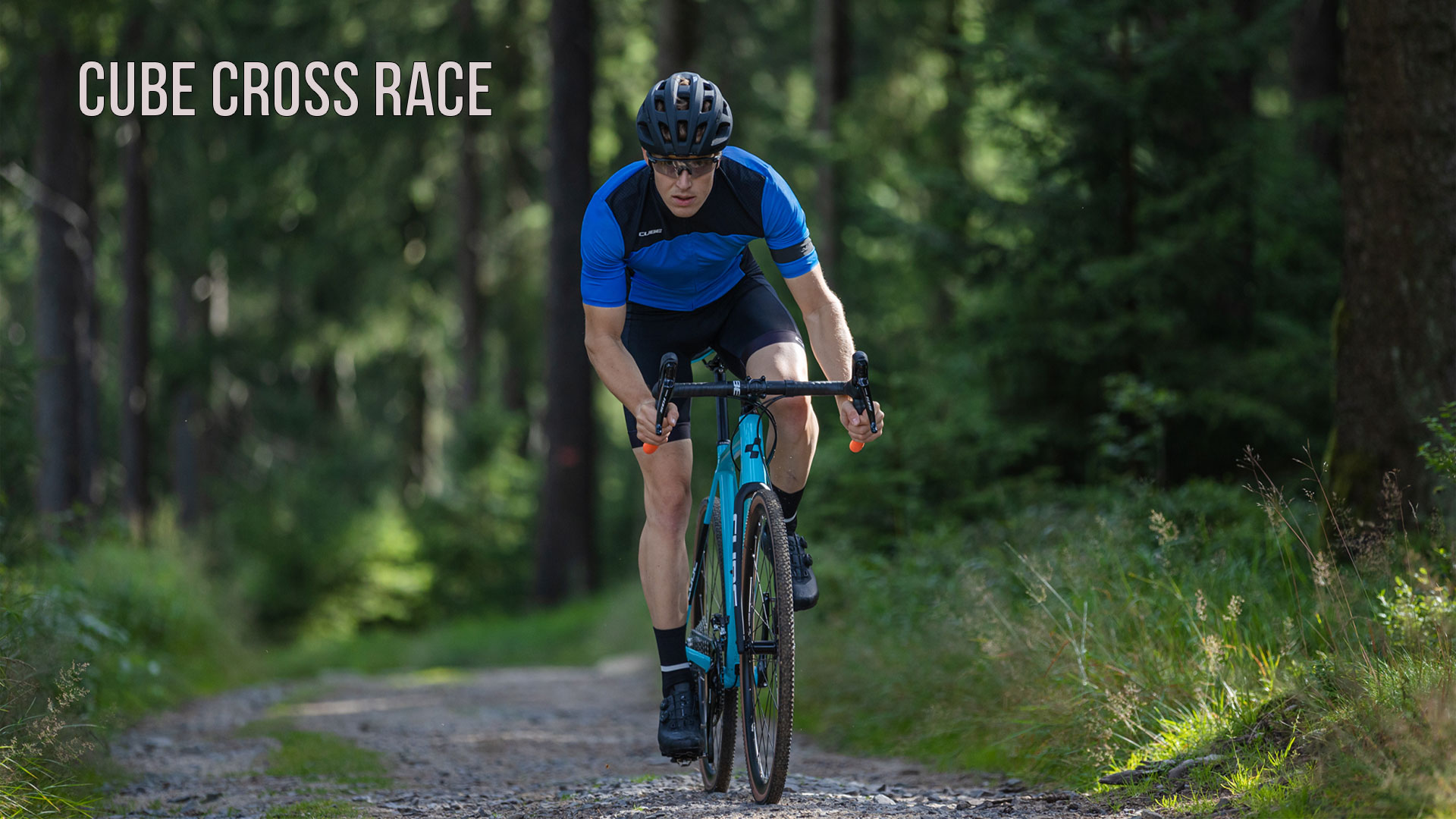 Un homme roule à vélo dans la forêt avec un vélo Cube Cross Race.
